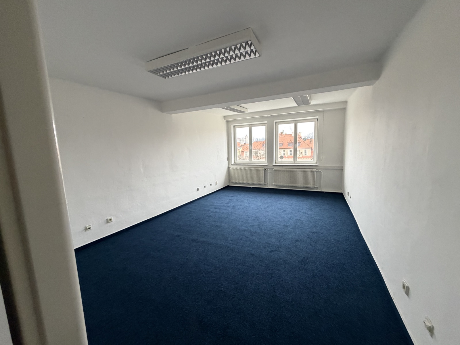 Office with two windows facing the rooftops